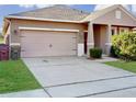 House exterior showcasing a two-car garage and neatly landscaped front yard at 1850 Patriot Way, Saint Cloud, FL 34769
