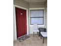 Red front door entry with small patio seating at 3016 Parkway Blvd # 109, Kissimmee, FL 34747