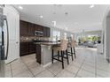 Modern kitchen with a center island, granite countertops, stainless steel appliances, and tile flooring at 3573 Bristol Cove Ln, St Cloud, FL 34772