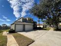 Two-story house with a three-car garage and side yard at 8557 La Isla Dr, Kissimmee, FL 34747