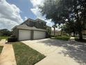 Exterior shot of a home featuring a large three-car garage and long driveway at 8557 La Isla Dr, Kissimmee, FL 34747