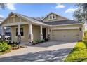 Tan house with stone accents, two car garage, and a nicely landscaped front yard at 8737 Leeland Archer Blvd, Orlando, FL 32836