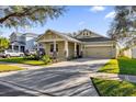 House exterior showcasing a light tan color, stone accents, and a 2 car garage at 8737 Leeland Archer Blvd, Orlando, FL 32836