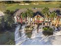 Townhouses next to a golf course with palm trees and paved driveways at 904 Assembly Ct, Reunion, FL 34747