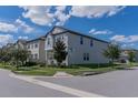 Two-story house with gray siding, white trim, and a landscaped yard, viewed from the side at 10415 Austrina Oak Loop, Winter Garden, FL 34787