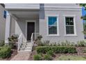 House entrance with dark brown door, white railings, and well-maintained landscaping at 10415 Austrina Oak Loop, Winter Garden, FL 34787