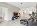 Open living area with a leather sectional and a large TV at 1066 Quaker Ridge Ln, Davenport, FL 33896