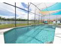 Screened pool and patio overlooking a tranquil lake at 160 Hideaway Beach Ln, Kissimmee, FL 34746
