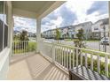 Covered front porch with white railings overlooking a residential street at 1829 Tropical Palms Cir Cir, Kissimmee, FL 34747