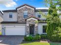 Two-story house with stone accents and a landscaped front yard at 185 Mitchells Mnr, Haines City, FL 33844