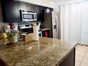 Kitchen features granite countertops and dark cabinetry at 1855 Caralee Blvd # 2, Orlando, FL 32822