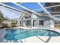 Relaxing kidney-shaped pool with screened enclosure at 201 Steamboat Blvd, Davenport, FL 33897
