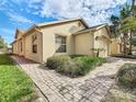 Well-maintained single-story home showcasing tidy landscaping and a brick walkway connecting the front to the side at 504 Millifiora Ln, Kissimmee, FL 34759