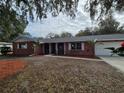 Red brick ranch home with mature landscaping and oak tree at 802 Peters St, Wildwood, FL 34785