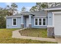 Front entrance of a newly constructed home with a walkway and landscaping at 832 Marion Oaks Mnr, Ocala, FL 34473