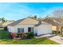 Front view of a single story house with a two-car garage and landscaping at 1201 Winding Willow Ct, Kissimmee, FL 34746