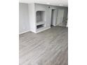 Bright living room with light gray walls, wood-look flooring, and a built-in shelving unit for storage or decor at 13803 Fairway Island Dr # S, Orlando, FL 32837