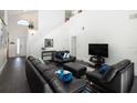 Spacious living room with black leather furniture and a large TV at 152 Pinewood Dr, Davenport, FL 33896