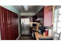 Galley kitchen with dark wood cabinets and stainless steel appliances at 1592 Martin Luther King Ne Blvd, Winter Haven, FL 33881