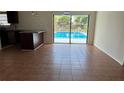 Open-concept living room with tile flooring leading to a sliding glass door and pool view at 1592 Martin Luther King Ne Blvd, Winter Haven, FL 33881