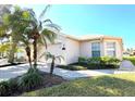 Single-story home with a light beige exterior, palm trees, and a paved driveway at 160 Rialto Rd, Poinciana, FL 34759