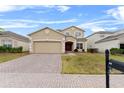 Two-story house with a brick driveway and landscaped lawn at 256 Lancaster Dr, Davenport, FL 33897