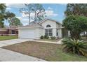 Charming one-story home features a two-car garage and well-maintained front lawn at 2993 Stillwater Dr, Kissimmee, FL 34743