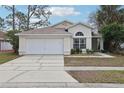 Lovely one-story home featuring an attached two-car garage and well-manicured front lawn at 2993 Stillwater Dr, Kissimmee, FL 34743