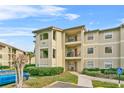 Condo building with walkway, landscaping, and parking at 3036 Parkway Blvd # 104, Kissimmee, FL 34747