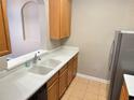 Kitchen with wood cabinets, double sink, and stainless steel refrigerator at 3326 Robert Trent Jones Dr # 10102, Orlando, FL 32835