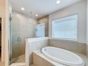 Bathroom featuring a soaking tub and walk-in shower at 524 Sardinia Cir, Davenport, FL 33837