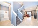 Two-story home entryway with staircase, bench, and view into living room at 5505 Misty Oak Cir, Davenport, FL 33837