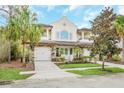 Two-story house with a two-car garage and lush landscaping at 8162 Valhalla Ter, Reunion, FL 34747
