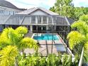 Screened-in pool area with hot tub and plenty of space for entertainment and surrounded by tropical palm trees at 8162 Valhalla Ter, Reunion, FL 34747