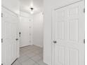Bright hallway with white tile flooring leads to the front door and features access to additional rooms at 1311 E 10Th St, Apopka, FL 32703