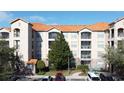 Exterior view of condo building with multiple balconies and a tree at 1361 Tuscan Ter # 7305, Davenport, FL 33896