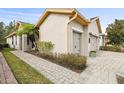 Tan house with a two-car garage and a brick paved walkway at 1813 Pelican Hill Way, Poinciana, FL 34759