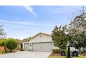 Two-story house with light colored walls, two car garage, and a paved driveway at 1813 Pelican Hill Way, Poinciana, FL 34759