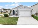 Gray house with white garage door and landscaping at 1956 Egret Meadows Ave, Kissimmee, FL 34744