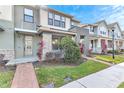 Modern two-story townhome with a welcoming front entrance and nicely landscaped yard at 2274 Centerra Loop, Kissimmee, FL 34741