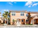 Two story townhome with light orange exterior and landscaping at 2621 Bugatti Ct, Kissimmee, FL 34746