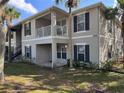 Two-story condo building with light beige exterior, dark gray shutters, and a private balcony at 3011 Hemingway Cir # 3011, Haines City, FL 33844
