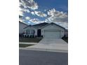 One-story home with two-car garage, landscaping, and a neutral color palette at 3309 Sonder Dr, Davenport, FL 33896
