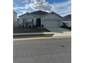 One-story home with two-car garage, landscaping, and a neutral color palette at 3309 Sonder Dr, Davenport, FL 33896