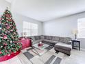 Living room featuring a gray sectional sofa, coffee table, and decorated Christmas tree at 370 Henley Cir, Davenport, FL 33896
