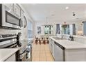 Open concept kitchen with stainless steel appliances and breakfast bar at 384 Orange Cosmos Blvd, Davenport, FL 33837