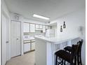 Efficient kitchen with white cabinetry and breakfast bar at 4105 Tropical Isle Blvd # 216, Kissimmee, FL 34741