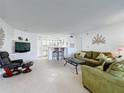 Living room features tiled floors, green sofa, and kitchen access at 4105 Tropical Isle Blvd # 216, Kissimmee, FL 34741