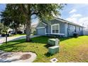 Inviting blue home with a well-maintained lawn and beautiful, mature shade trees at 435 Madina Cir, Davenport, FL 33837