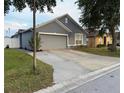 Charming single-story home featuring a gray exterior, a two-car garage, and a well-maintained front yard at 435 Madina Cir, Davenport, FL 33837